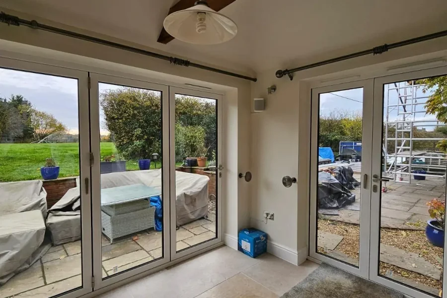 Garden room interior with limestone floor, exposed oak beam and bifold doors on two sides