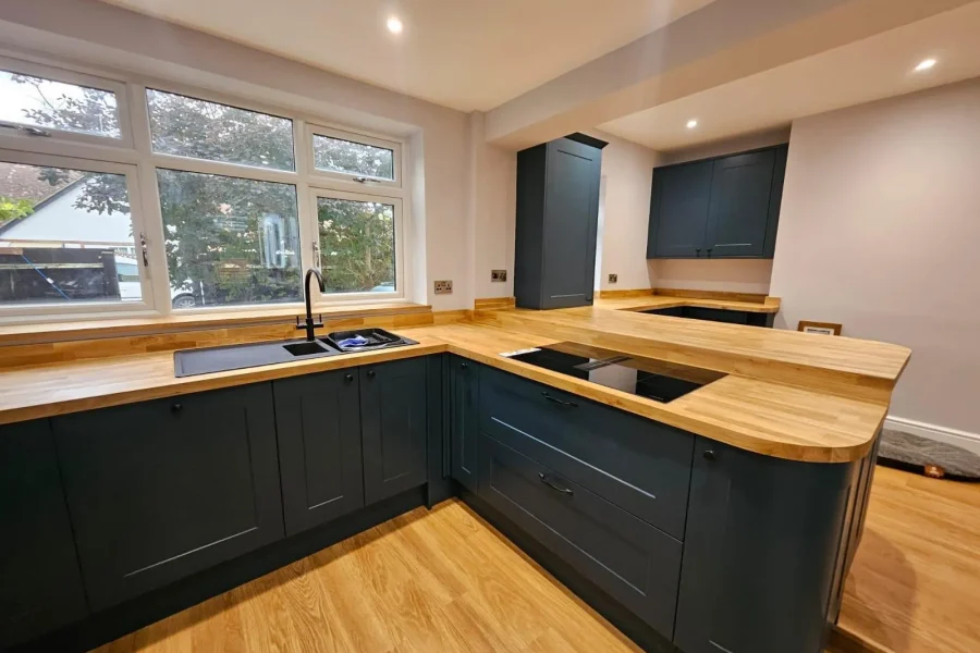 Finished navy shaker-style kitchen with solid oak worktops and black fittings