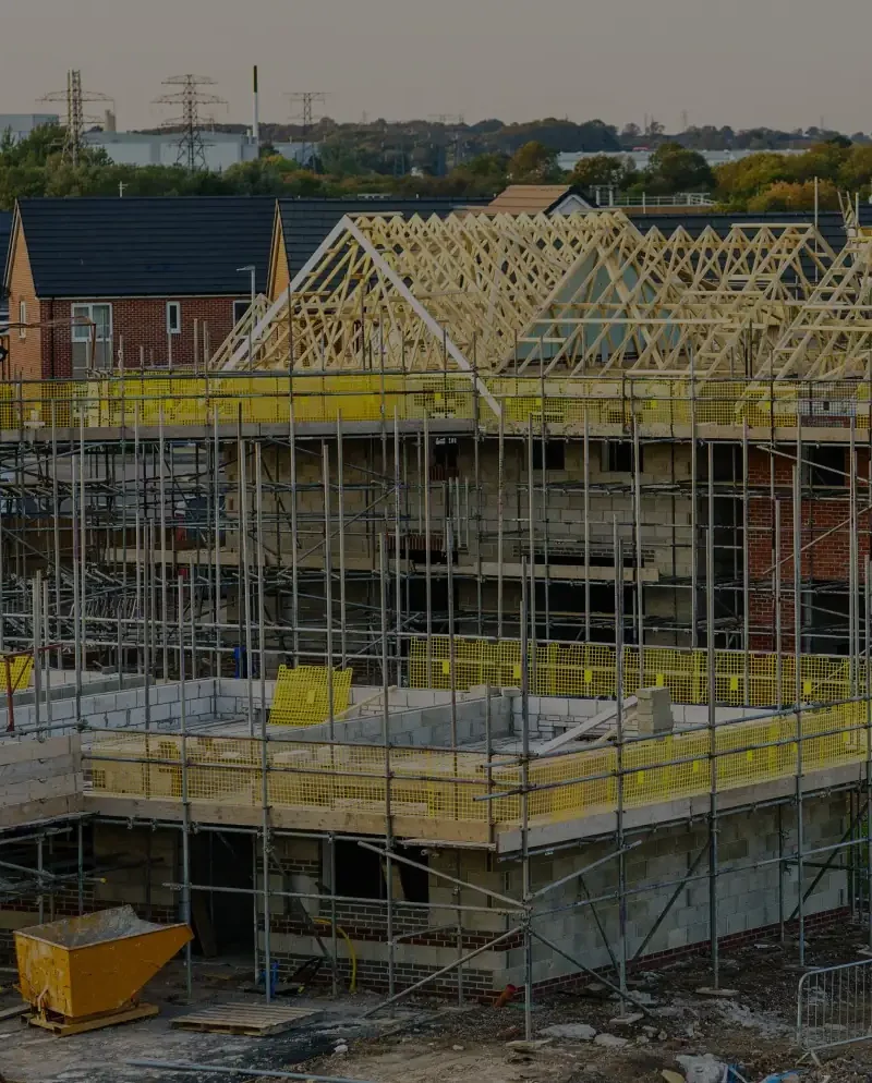 New build houses under construction with roof trusses and scaffolding