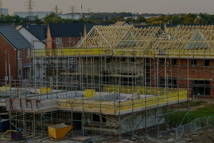 New build houses under construction with roof trusses and scaffolding