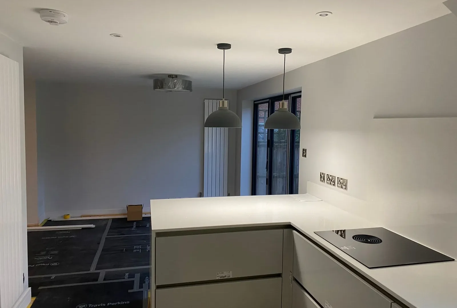 Newly fitted open-plan kitchen and dining area with pendant lights and bifold doors