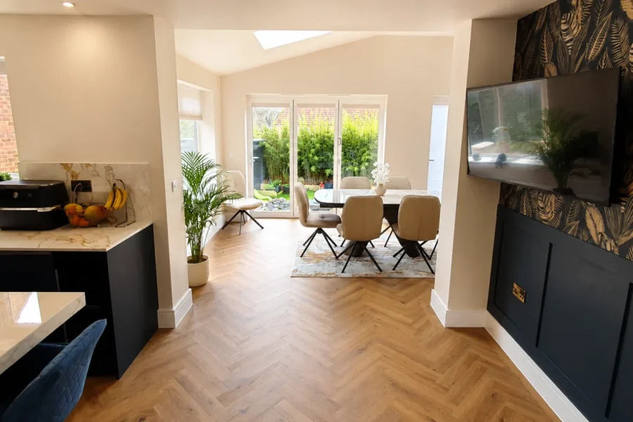 Kitchen diner extension with french doors to the garden, botanical feature wall and herringbone flooring