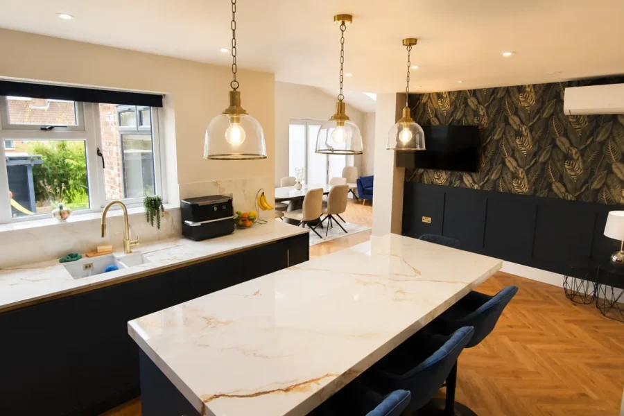 Kitchen extension with a window run over the sink and an open-plan dining area beyond