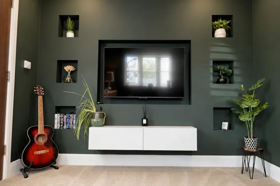 Bespoke green media wall with a recessed TV, six lit alcoves and a floating cabinet over cream carpet