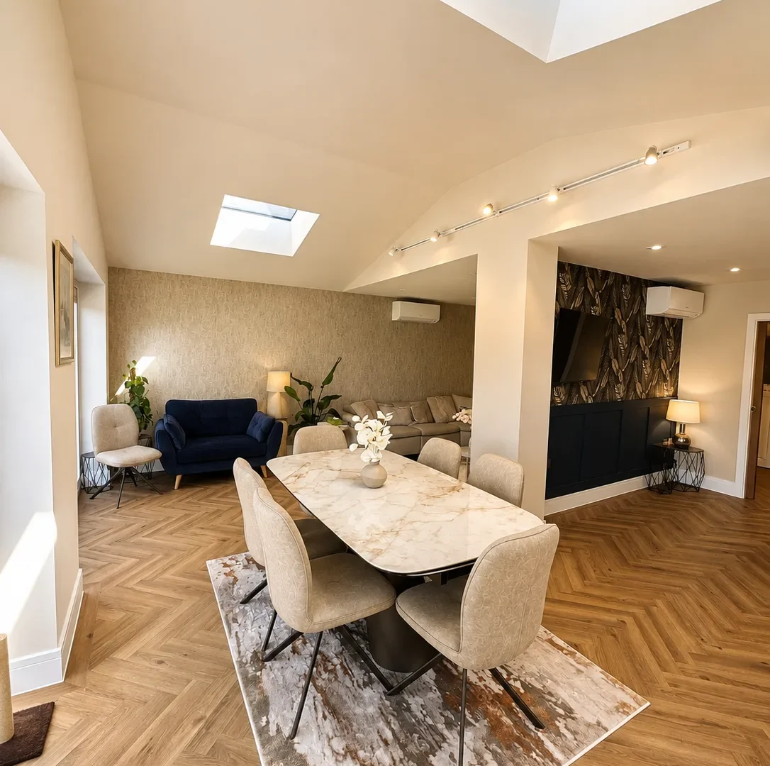 Vaulted open-plan dining area with two lantern rooflights, marble dining table and herringbone flooring