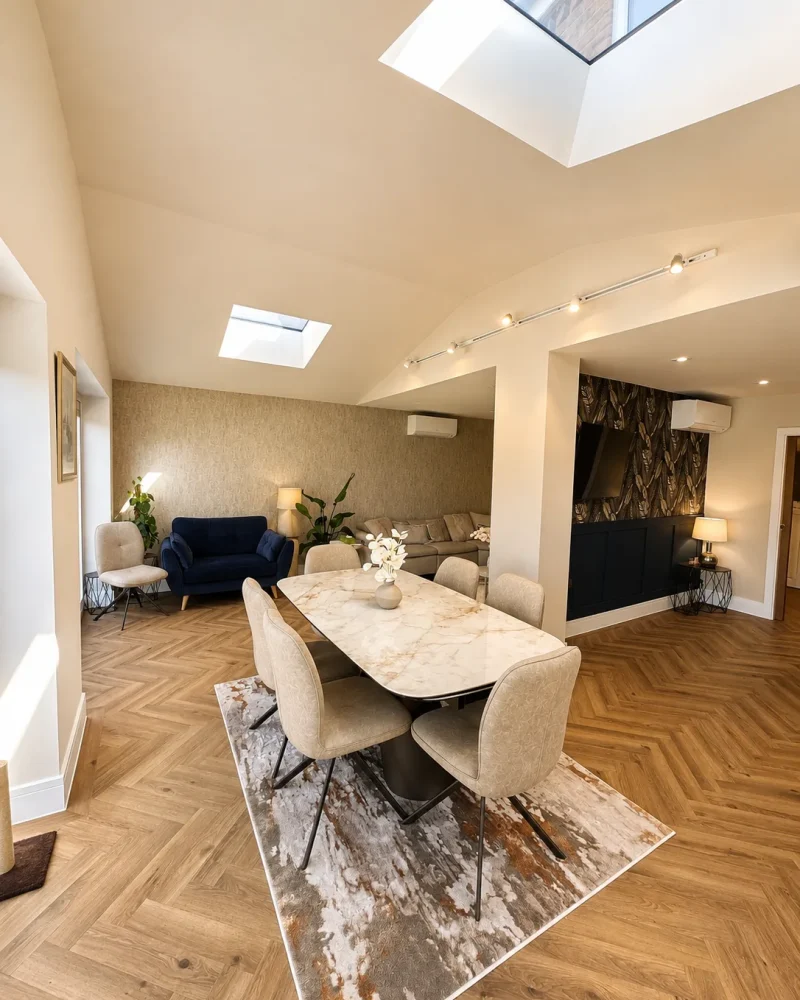 Vaulted open-plan dining area with two lantern rooflights, marble dining table and herringbone flooring